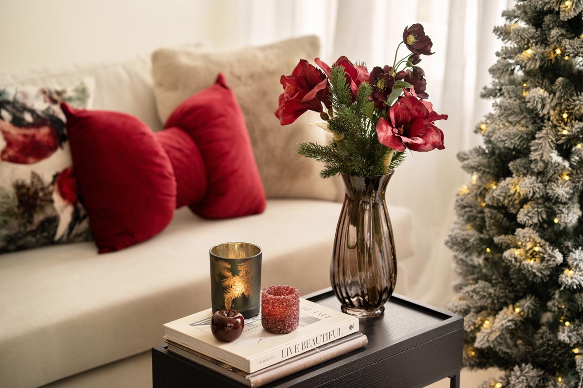 Vase med bukett på sidebord med julepynt