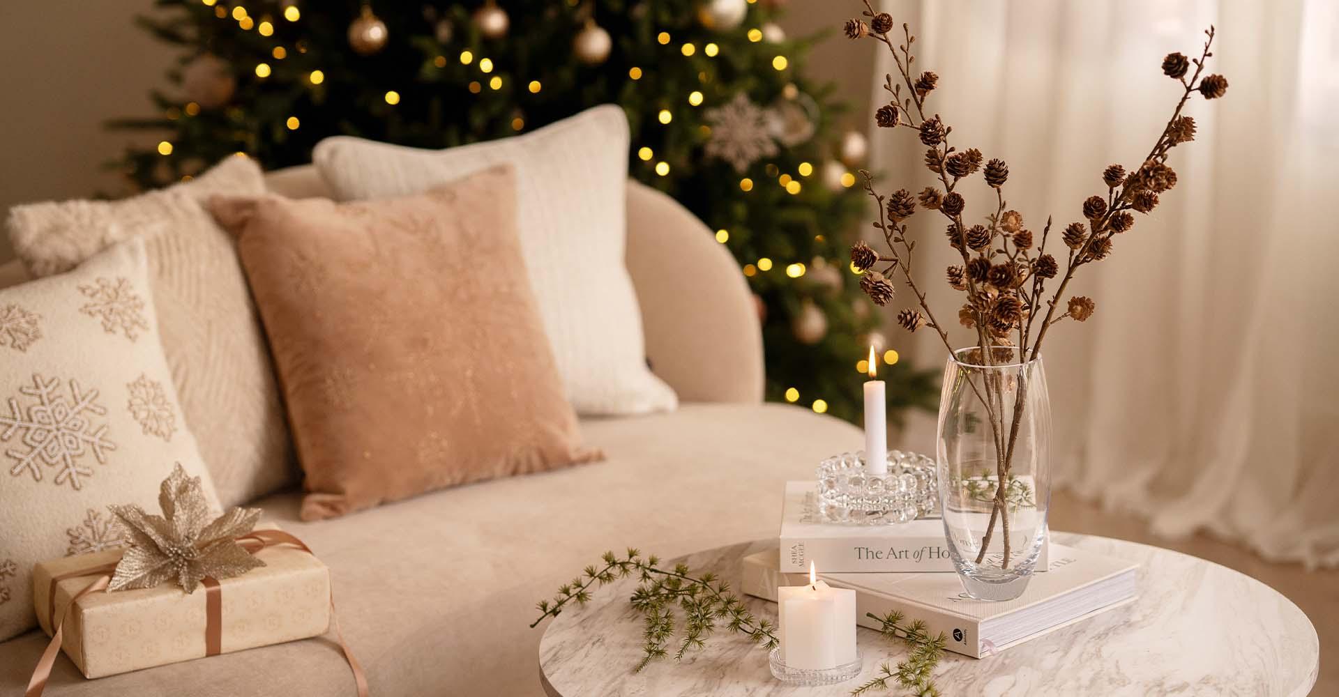 Bord med julepynt, lysestaker og vase med grener