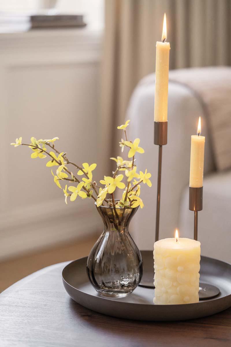 Vase med blomster og lyslykter på bordet