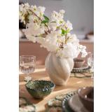 Vase med blomster på dekt middagsbord