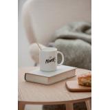 Hvit kopp med Girl power skrevet på - oppå trebord