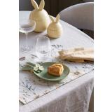 Bord dekt med dekkebrikke vårblomst, asjett hare og tøyserviett vindel