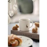 Kopp med haremotiv stående sammen med små kanindekorasjoner