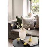 Vase med gåsunger og glassegg på sofabord med dekorfigurer