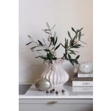 Vase med olivengrener og glitteregg sammen med påskeegg på kjøkkenbenk