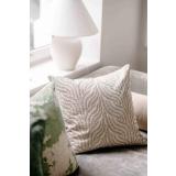 Putetrekk gren brodert grønn i sofa med vårsola som skinner inn