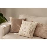 Putetrekk i saga brodert i sofa med beige puter