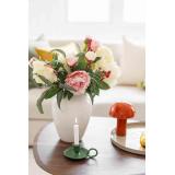 Peon bukett i vase på sofabord med lampe og lysestake