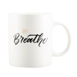Hvit kopp med hank og skrift med Just Breathe