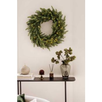 Lys, vase og krukke på konsollbord med krans hengende over