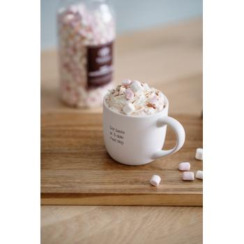 kopp med teksten det beste er å dele på bord med kakao og marshmallows