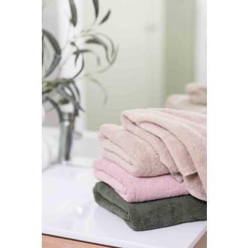 Håndklesett i beige, rosa og grønn på baderom