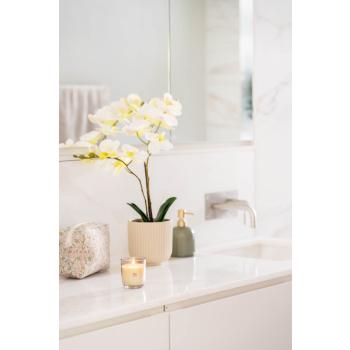 Baderom med orkide, såpepumpe, duftlys og toalettmappe