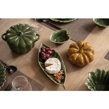 Servering av ost på fat leaves på spisebord med dekor