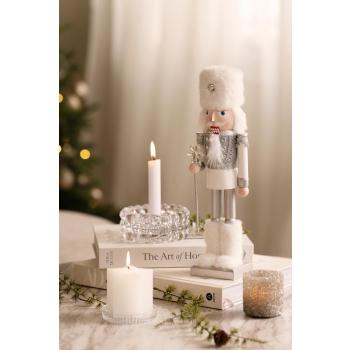 Nøtteknekker med pelsboots på sofabord med lysestaker