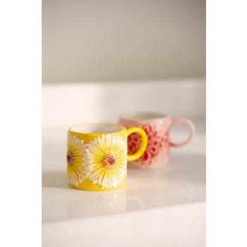 Kopp solsikke og peon på kjøkkenbenk