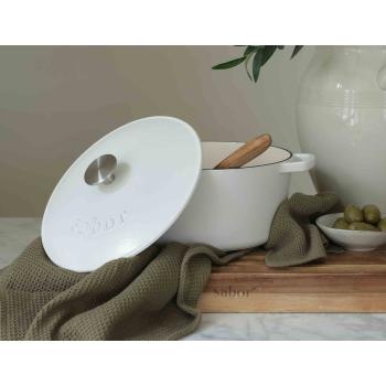 Grønt kjøkkenhåndkle med støpejernsgryte på fjøl