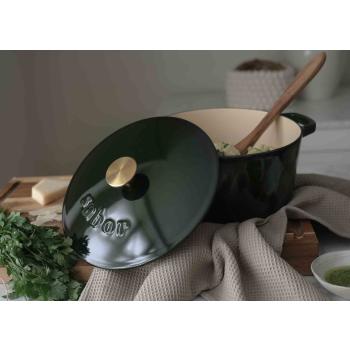 Grått kjøkkenhåndkle med støpejernsgryte på fjøl