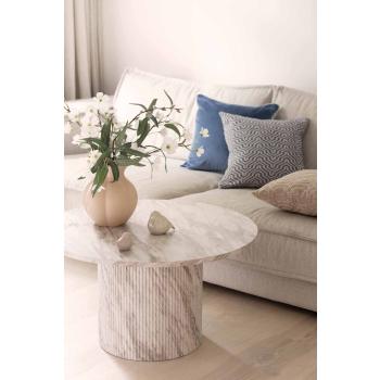 Stue med blå puter i sofa og sofabord med vase og dekorfigurer