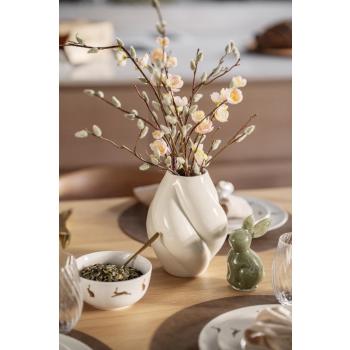 Skål fra hareserviset på bord med glasskanin og vase med blomster