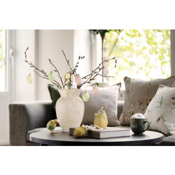 Vase med gåsunger og glassegg på sofabord med dekorfigurer