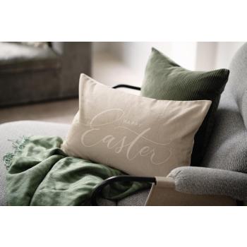 Stol stylet med putetrekk i grønn og påsketrekk og et grønt pledd