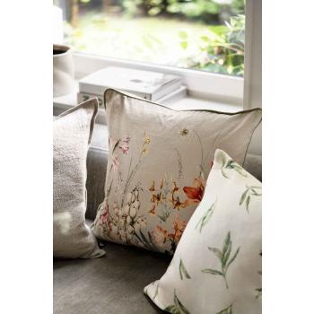 Putetrekk med blomstermotiv i stue i kombinasjon med beige puter