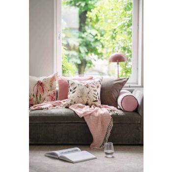 Sofa med puter og pledd i rosa toner