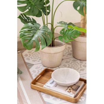 Serveringsbrett med dekorskål og utepotte på uteteppe på balkong